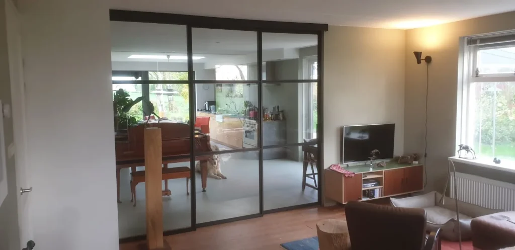 Twee schuifdeuren met glas en zwarte kozijnen.