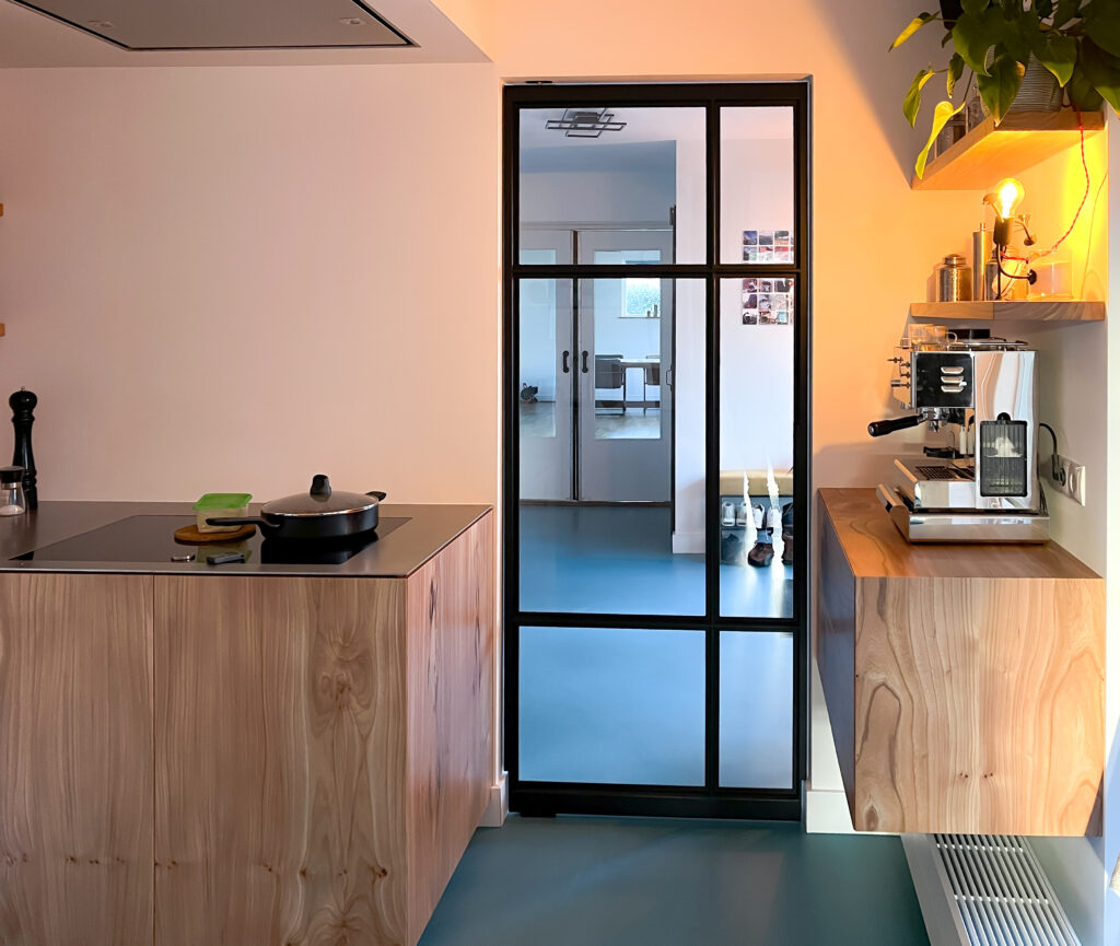 "Taatsdeur met glas en zwarte kozijnen."