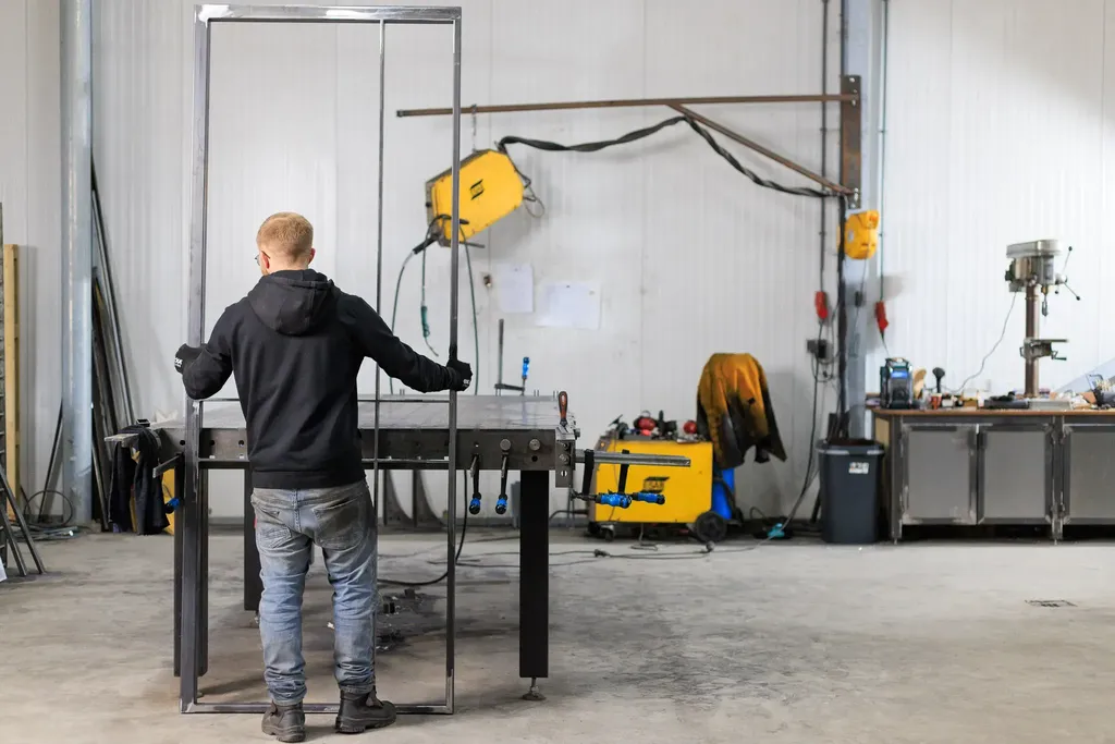 Medewerker Maatwerk met stalen deur in zijn handen